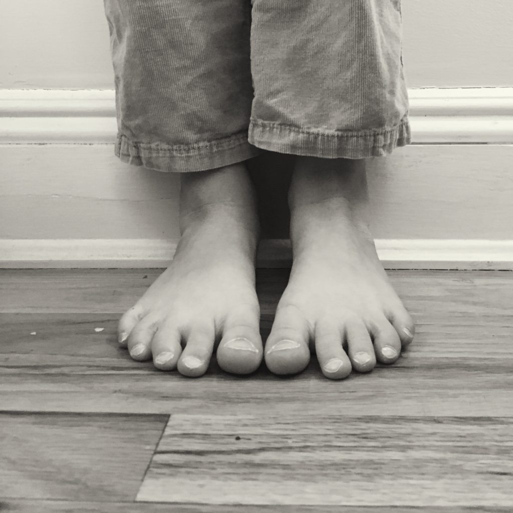 C's feet, wearing pants she's outgrown