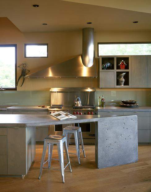 A stainless-steel hood custom-designed by a California artist mimics the lines of the poured-concrete island.