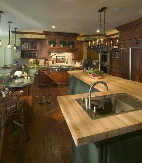The large L-shaped island provides a comfortable workspace for several cooks at once. The artwork above cooktop has since been replaced with a mural, painted on canvas so it can be relocated, of the family’s horses and dog in a California pasture. 