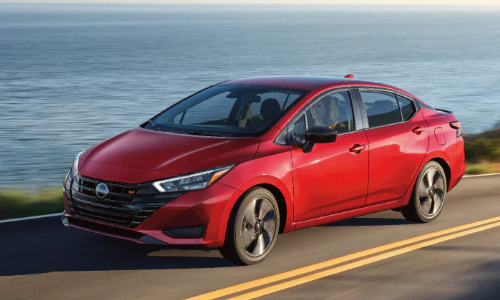 Nissan Red Sedan side image Red Nissan Sedan driving on the highway
