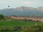 A solitary walker has the Verde Santa Fe Golf Course in Cornville Az to himself. Colorful balloons are a frequent sight over the course in the early morrnings.