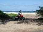 Young girl riding ATV along beach.  Police officer stopped her and her brother who was just ahead of her on an ATV just after picture was taken.