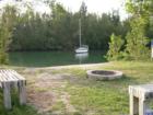 A sailboat hidden in quiet waters near the cabin at Oleta River Park. Benches and a fire pit provide outdoor fun when camping out in Miami.