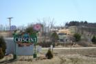 Welcome sign at the edge of Crescent, Iowa with a new subdivision in the background.