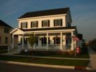 This farmhouse style home has a wrap around porch and a screen porch connector from the garage to the house.