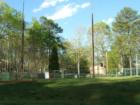 This is a picture with the community tennis courts in the foreground and the pool in the far distance in the Laurel Thicket section of Carolina Trace in Sanford, NC