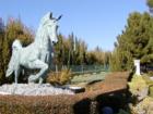 Well-manicured landscaping and exquisite horse sculptures flank the entrance to the guard-gated community of Queensridge in Las Vegas, NV.