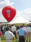 This is a picture of the ground breaking ceremony for the new Wal-greens distribution center. Notice the hot air balloon in the background.