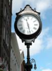 A sidewalk clock located in the Greenpoint section of Brooklyn. One of the city's few remaining freestanding cast-iron clocks, now protected by landmark designation.  