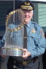 Hamilton's Police Chief holding the Red Sox World Series Championship trophy.