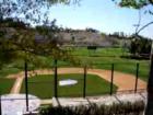 The lighted softball field features bleacher seating and dugouts.