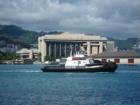 Tug boat heading out to escort large ship into the harbor.