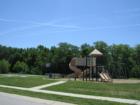 Playground at Forest Knoll - lots of green grass, play equipment and basketball.