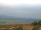 This is a view from a cliff that shows farms like patchwork in the valley floor