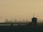 A common southern California sight are the artificial islands (in the distance) built to comouflage oil rigs off shore.  An empty lifeguard station is in the foreground.