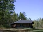 This owner-built log cabin was hand-hewn from native logs on the site and constructed using salvage materials.