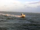 A boat entering the inlet from a nice day in the ocean. 