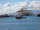 Matson container ship being unloaded as tug passes by