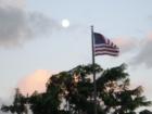 The moon overlooks the American Flag