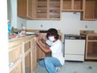My helper refinishing one of my properties kitchen cabinets
