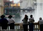 Tourists look on as the Bellagio fountains shoot into the air. Seen in the background is a changing Vegas...Cosmopolitan Resort and MGM MIRAGE CityCenter.  November 2007