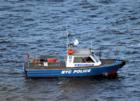 NYPD boat in water while police officers walked the span of Verrazano-Narrows Bridge