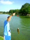 Young man holding fish he just caught in Cinco Ranch south lake.  "I always take my camrea when I go for a walk around the lake, I cme up just as he caught his fist".  Photo by Liz Carter, local realtor and resident
