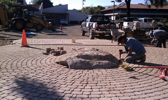 installing large boulder in paver mandala