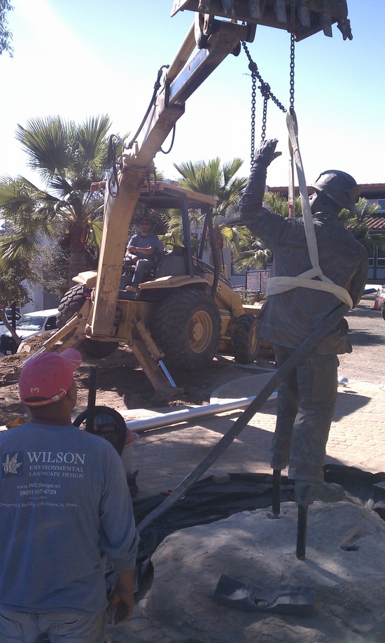 setting firefighter statue onto boulder