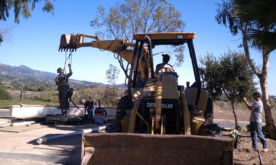 lifting statue with backhoe extended boom