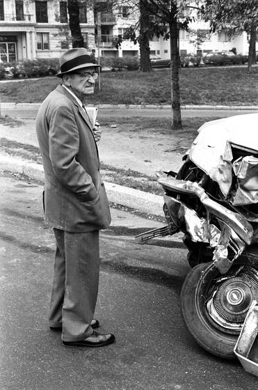Old_man_looking_at_car