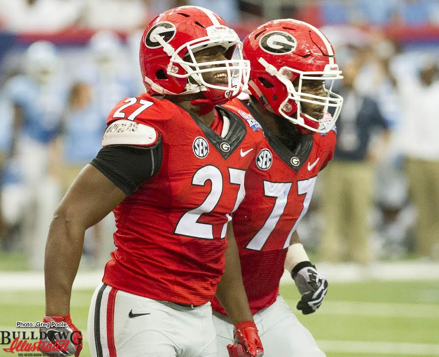 Nick Chubb (27) with a big smile after scoring a TD with Isaiah Wynn (77)