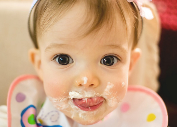 Amber enjoys her first taste of cake at her first birthday party. Large