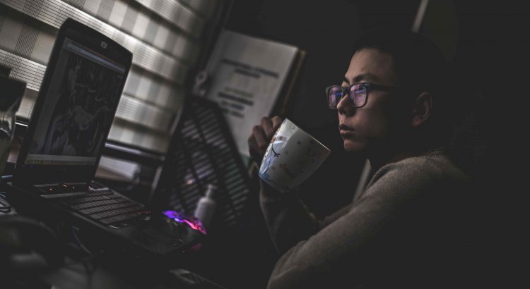 homem oriental olhando para o computador