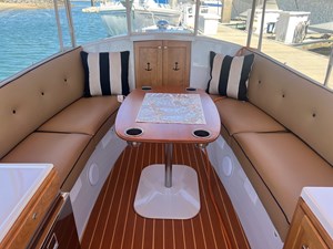 Port and starboard sits with cushion; Large teak table with four drink holders