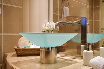 One of the elegant glass vessel sinks and it's exquisite fixtures
