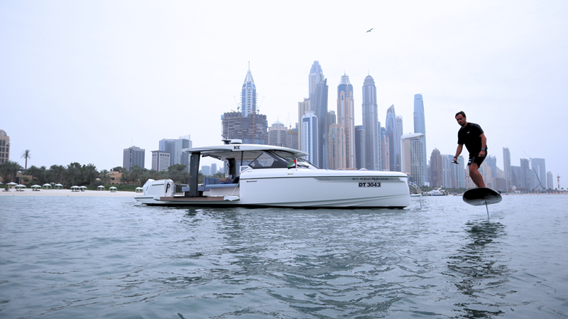 Starboard side view of Saxdor 400 GTO ICE yacht underway in Dubai with modern skyscrapers in background.