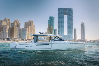 Side profile of Saxdor 400 GTO ICE yacht cruising in Dubai Marina with skyline in the background.