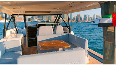 Saxdor 400 GTO ICE cockpit lounge with wraparound seating, wooden dining table, and panoramic Dubai Marina skyline views.