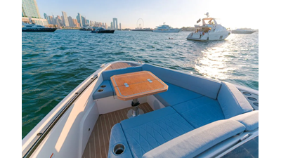Saxdor 400 GTO ICE Bow seating area with teak table on a luxury yacht, overlooking the ocean and nearby yachts in the harbor.