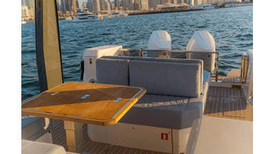 Saxdor 400 GTO ICE cockpit lounge with wraparound seating, wooden dining table, and panoramic Dubai Marina skyline views.