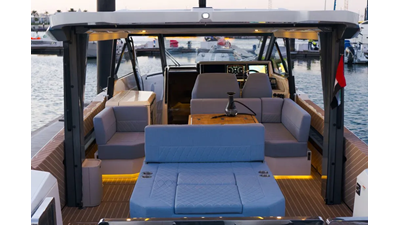 Saxdor 400 GTO ICE cockpit lounge with wraparound seating, wooden dining table, and panoramic Dubai Marina skyline views.