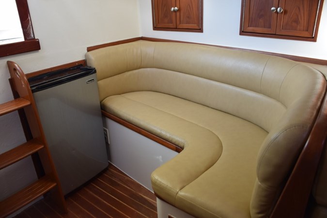 L-shape settee and refrigerator. Small cabinet storage above