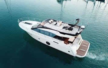 Exterior side view of Monte Carlo 5 slowly cruising on blue waters