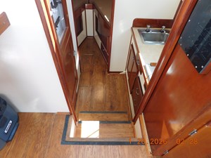 Steps down to galley, head, and berth. Laminate wood flooring.