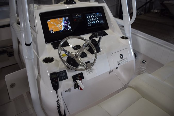 2017 Intrepid 327 Open boat dashboard with steering wheel and navigation screens.
