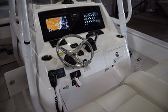 2017 Intrepid 327 Open boat dashboard with steering wheel and navigation screens.