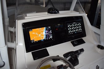 Magnetic compass on top of helm, Fusion stereo to starboard.