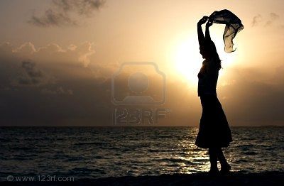 1415078-silhouette-of-young-girl-dancing-on-the-beach-at-sunset