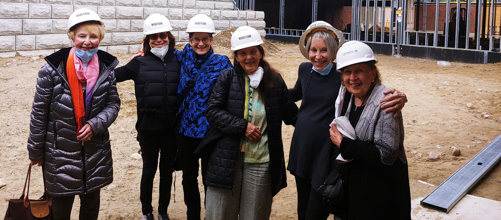 capital campaign chairs in front of new campus construction